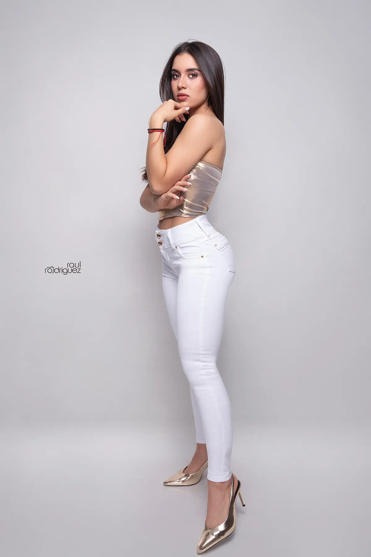 Detalle frontal de jeans blancos con cintura alta, bolsillos y botones dorados